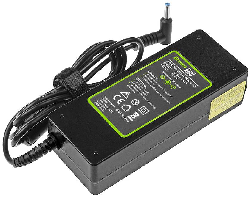 Schwarzes Laptop-Ladegerät mit angestecktem Kabel. Produktaufkleber zeigt technische Spezifikationen und grüne Farbakzente.