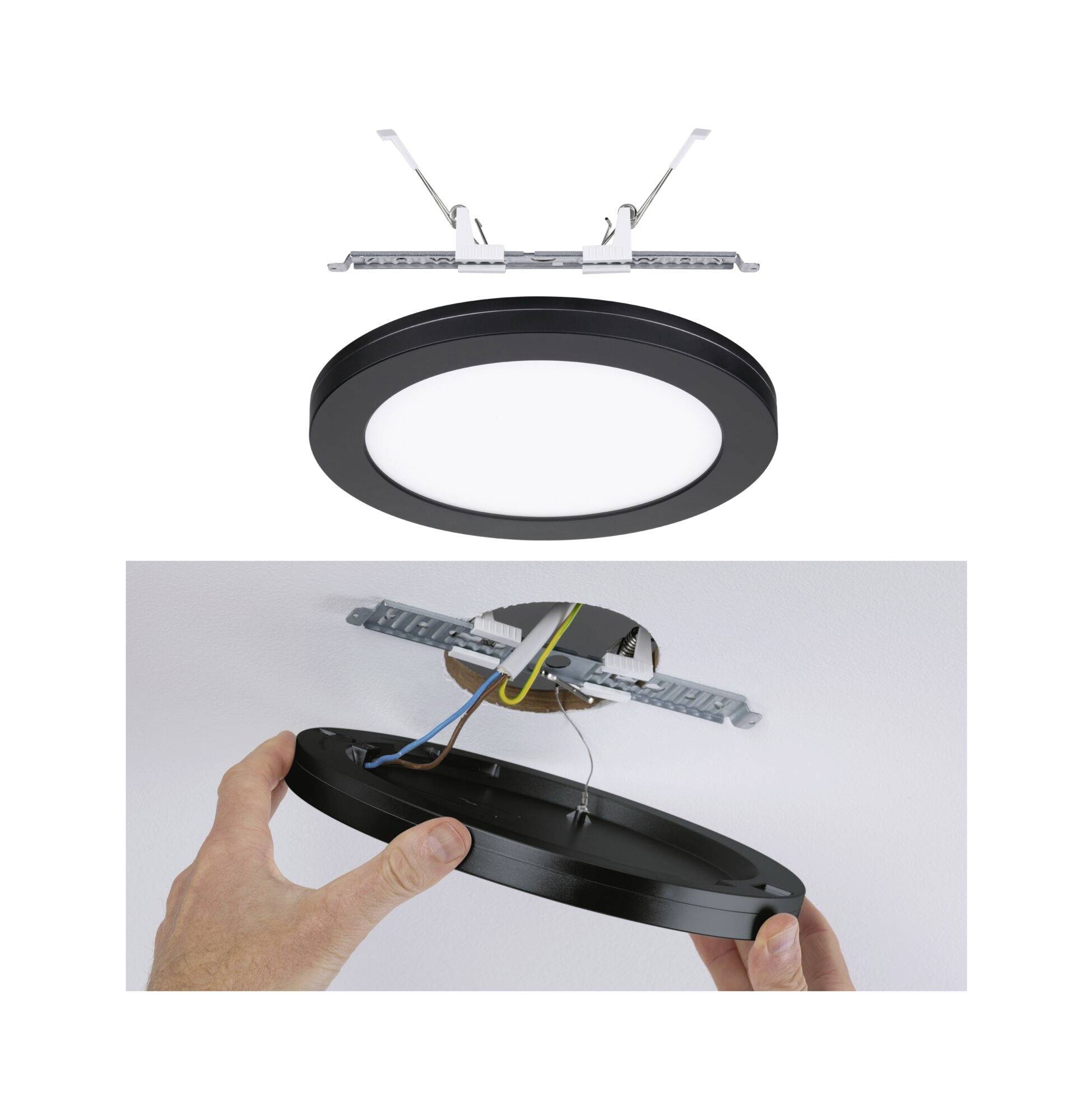 Das Bild zeigt eine runde, schwarze Deckenleuchte. Oben sieht man die Befestigungsvorrichtung, unten eine Hand, die die Lampe anbringt.