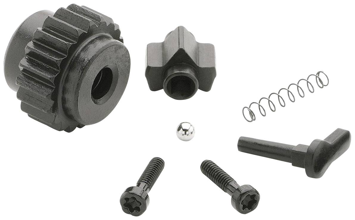 Mehrere schwarze mechanische Teile, darunter ein Zahnrad, Feder, Kugel und Schrauben. Sie könnten Teil eines komplexen Geräts sein.