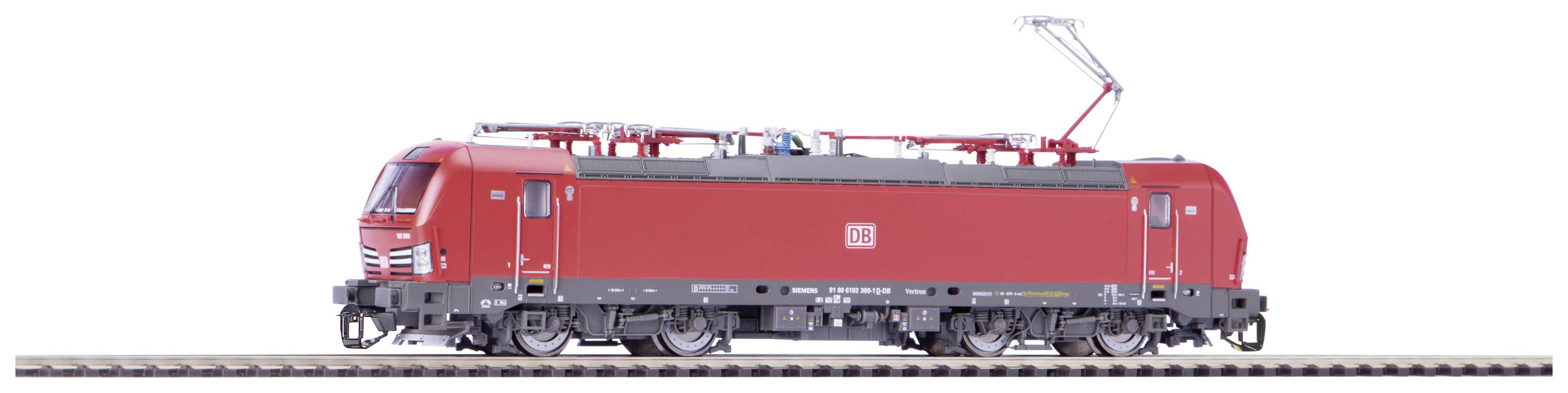Rotes Modell einer elektrischen Lokomotive auf Gleis, seitlich fotografiert, mit sichtbarem Pantographen nach oben gerichtet.