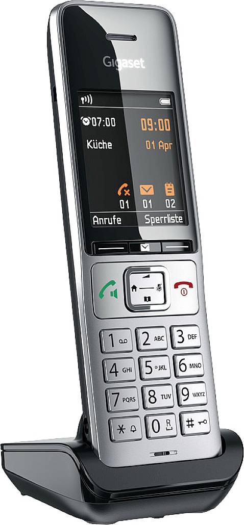 Schnurloses Telefon im Ladestation-Halter. Display zeigt Uhrzeit, Datum und 'Küche'. Tastenfeld mit Nummern und Funktionstasten.