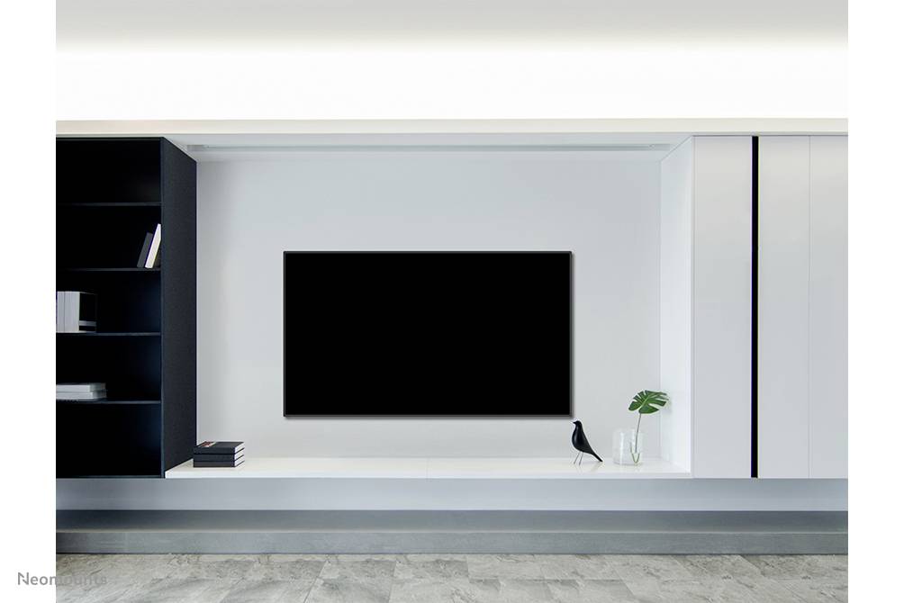 Moderne Wohnzimmereinrichtung mit einem großen, schwarzen Flachbildfernseher an einer weißen Wand, daneben ein Regal und eine Vase.
