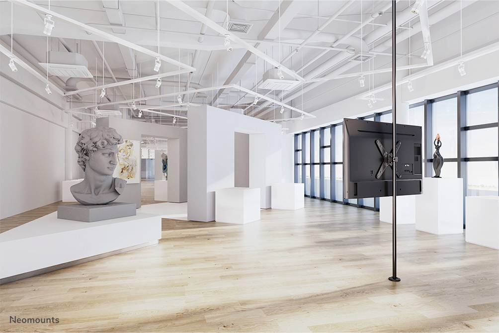 Ein moderner, heller Ausstellungsraum mit weißen Wänden, Holzboden, einer Skulptur eines Kopfes und großen Fenstern im Hintergrund.