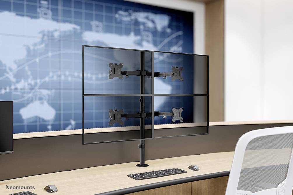 Ein Schreibtisch mit einem Monitorhalterungssystem für vier Bildschirme, im Hintergrund eine Weltkarte und modernes Design.
