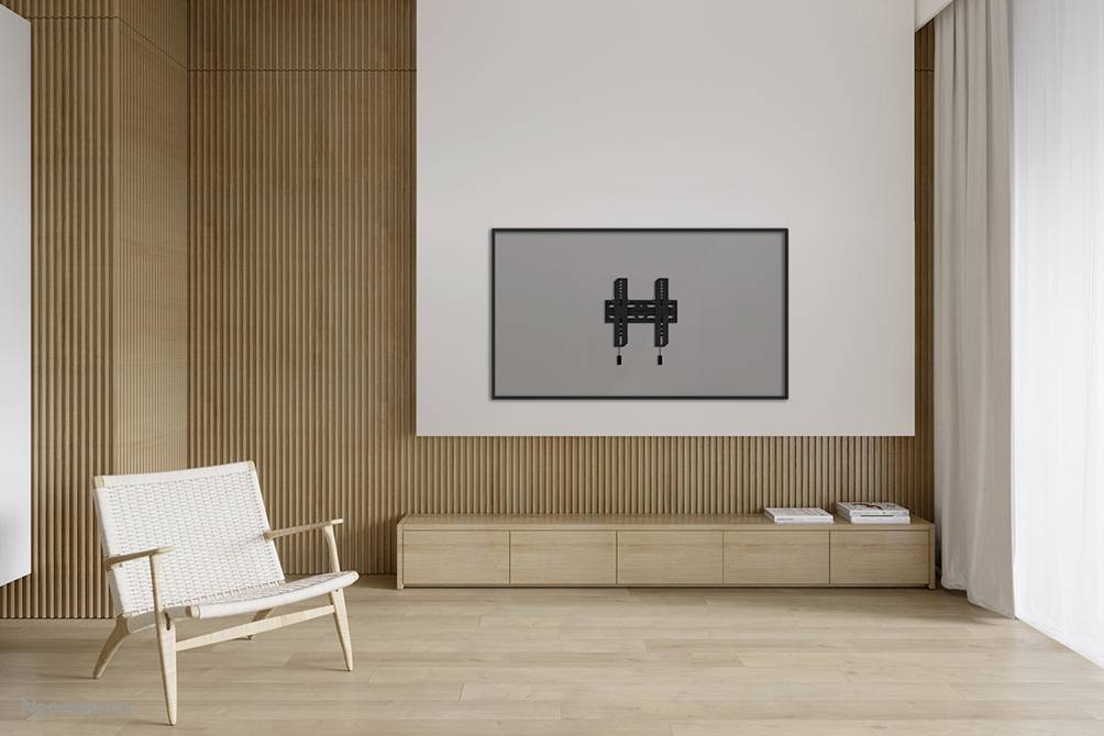 Heller Raum mit Holzboden, einem Sessel links und einer Wandhalterung für einen Fernseher oder Monitor an der weißen Wand rechts.