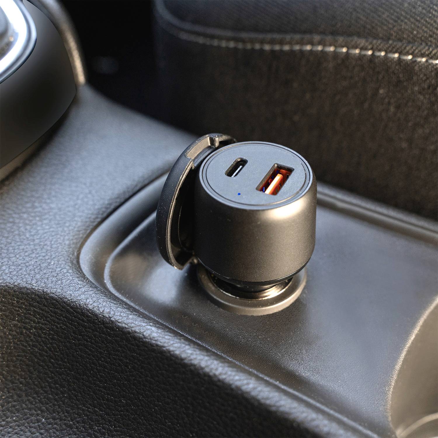 USB-A- und USB-C-Ladegerät in einer Autositzkonsole, bereit zum Aufladen.