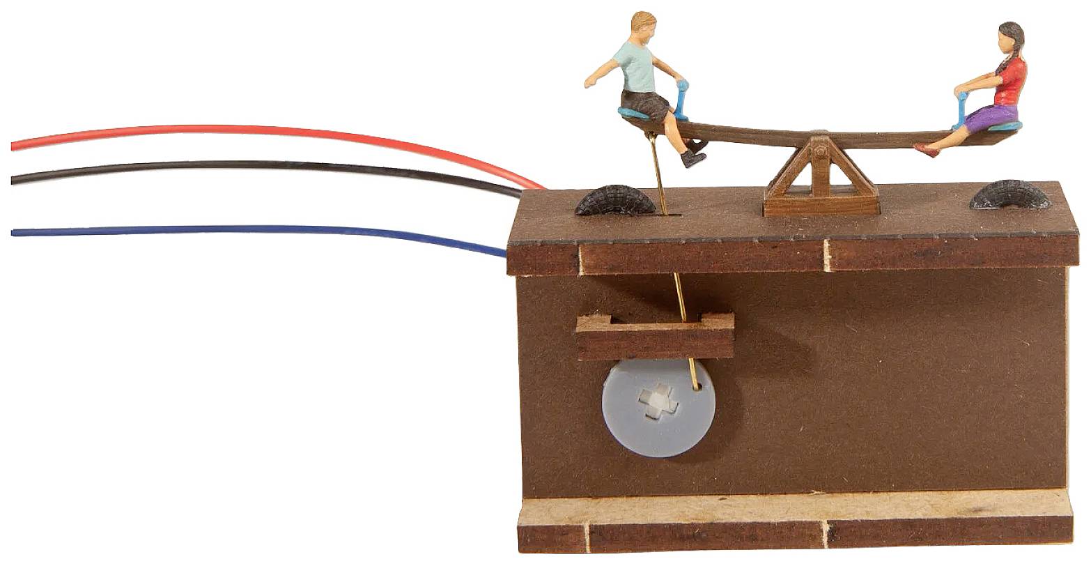 Ein Modell einer Wippe mit zwei Figuren, die darauf sitzen. Kabel sind an der Konstruktion befestigt, was auf eine elektrische Verbindung hinweist.