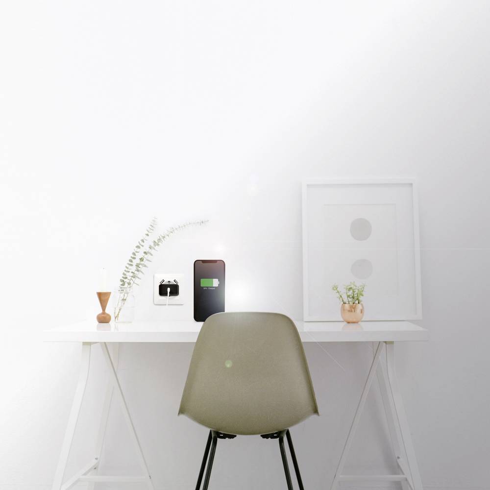 Ein minimalistischer Schreibtisch mit grünem Stuhl. Darauf stehen ein Smartphone, Vasen und ein Bildrahmen. Helle, moderne Atmosphäre.