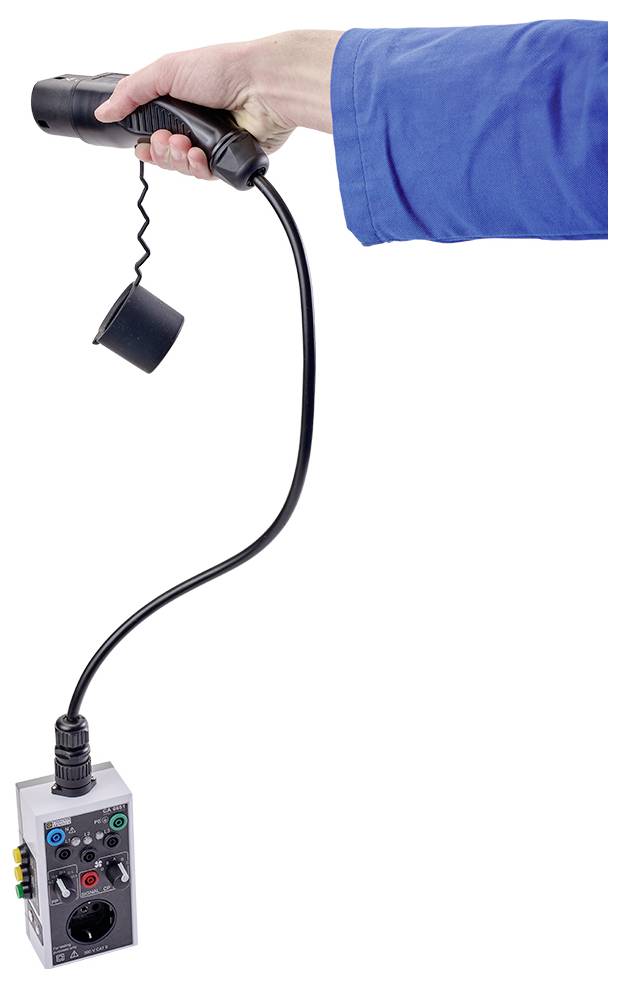 Eine Hand hält ein schwarzes Gerät mit Kabel, an dem eine graue Konsole mit bunten Knöpfen und einem Steckplatz hängt.