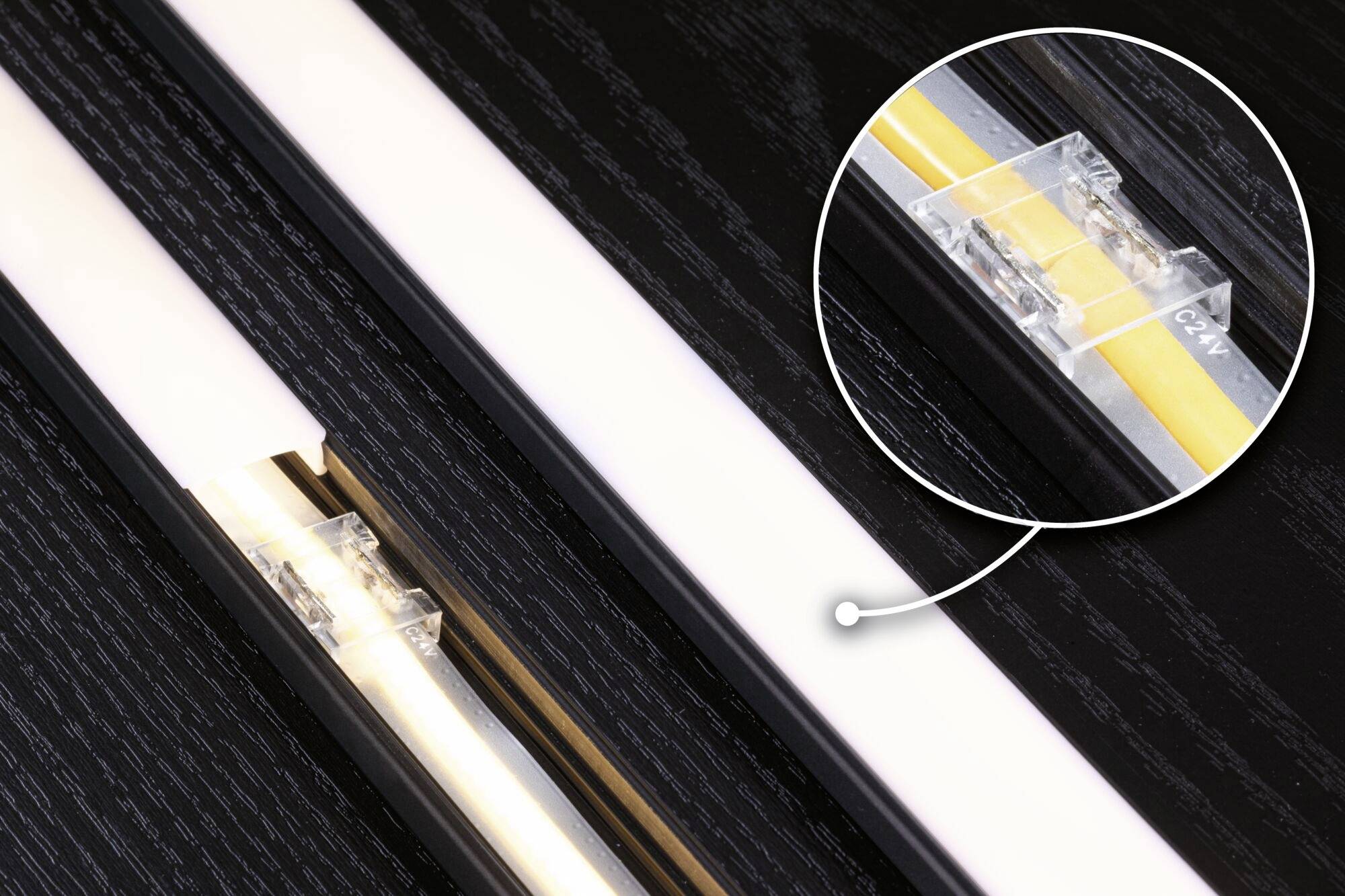 Eine LED-Leiste in Nahaufnahme zeigt ein transparentes Verbindungselement in einer kreisförmigen Vergrößerung.