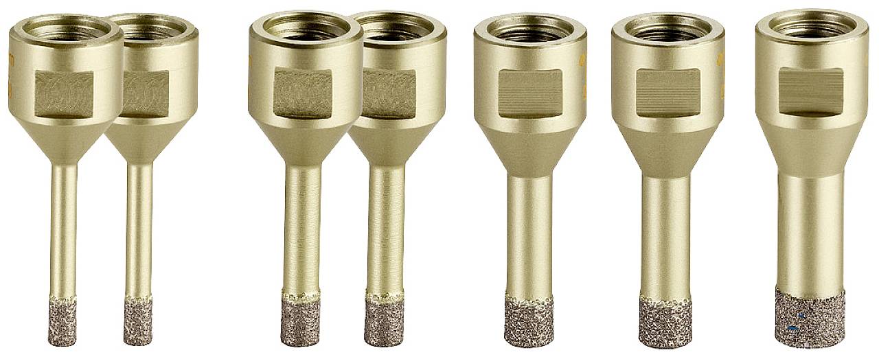 Sechs goldfarbene Bohrkronen in Reihe, jeweils mit unterschiedlich langen Schäften und diamantbesetzten Spitzen, stehen aufrecht.