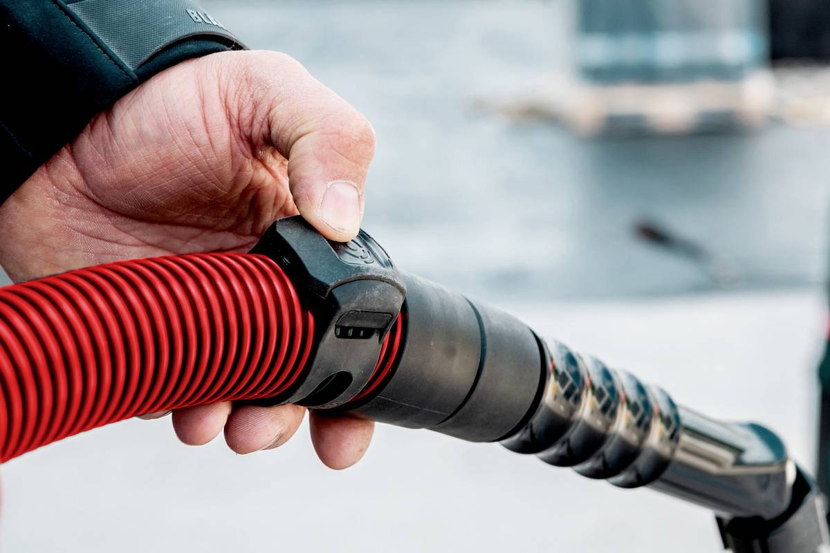 Person hält eine rote Elektroladestation-Düse, zeigt den Vorgang des Fahrzeugladens.