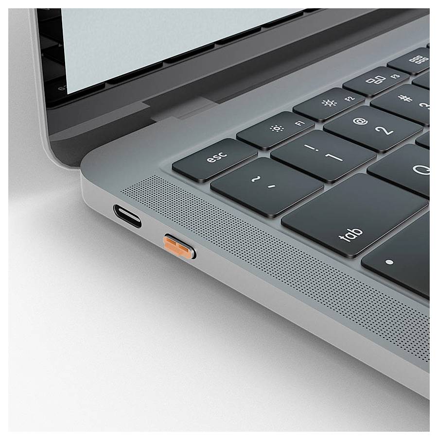 Nahaufnahme einer Laptop-Ecke mit Tastatur, Lautsprechergitter und Ladeanschluss mit angeschlossenem orangefarbenem USB-C-Adapter.