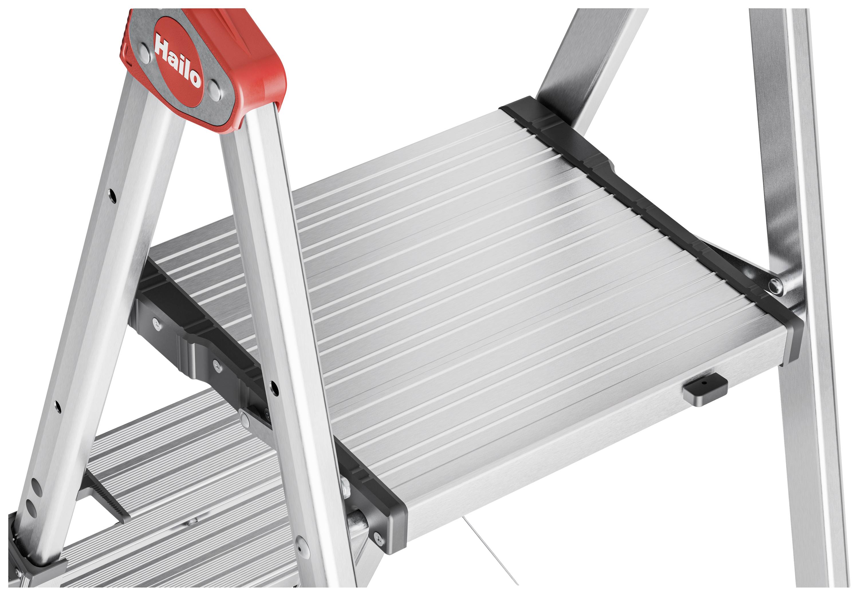 Eine silberne Alu-Leiter mit großen Stufen für sicheres Stehen, rote Akzente an den Ecken. Geeignet für den Einsatz im Innenbereich.