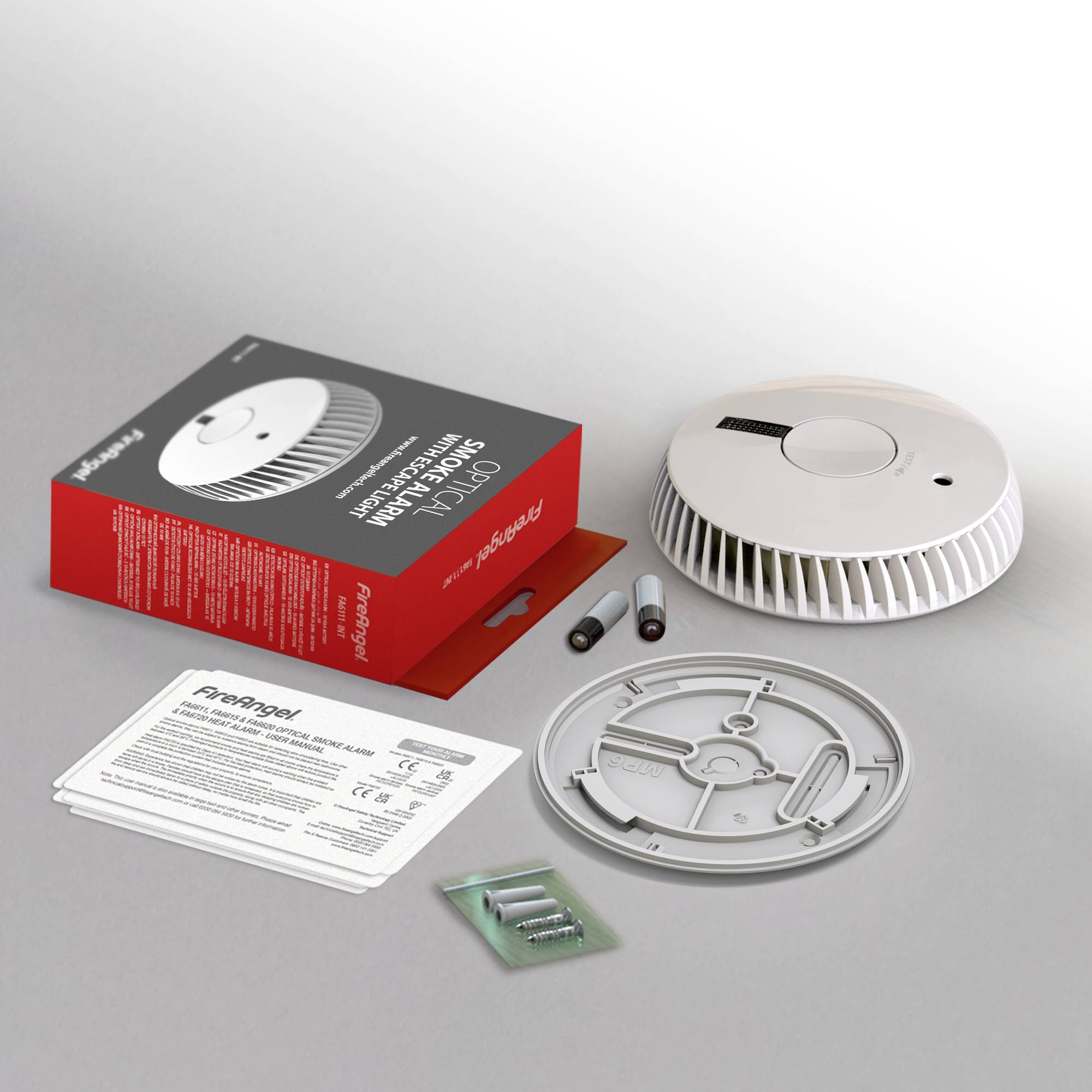Eine Rauchmelder-Box neben einem geöffneten Rauchmelder, Batterien, Montageplatte und Anleitung auf einem Tisch.