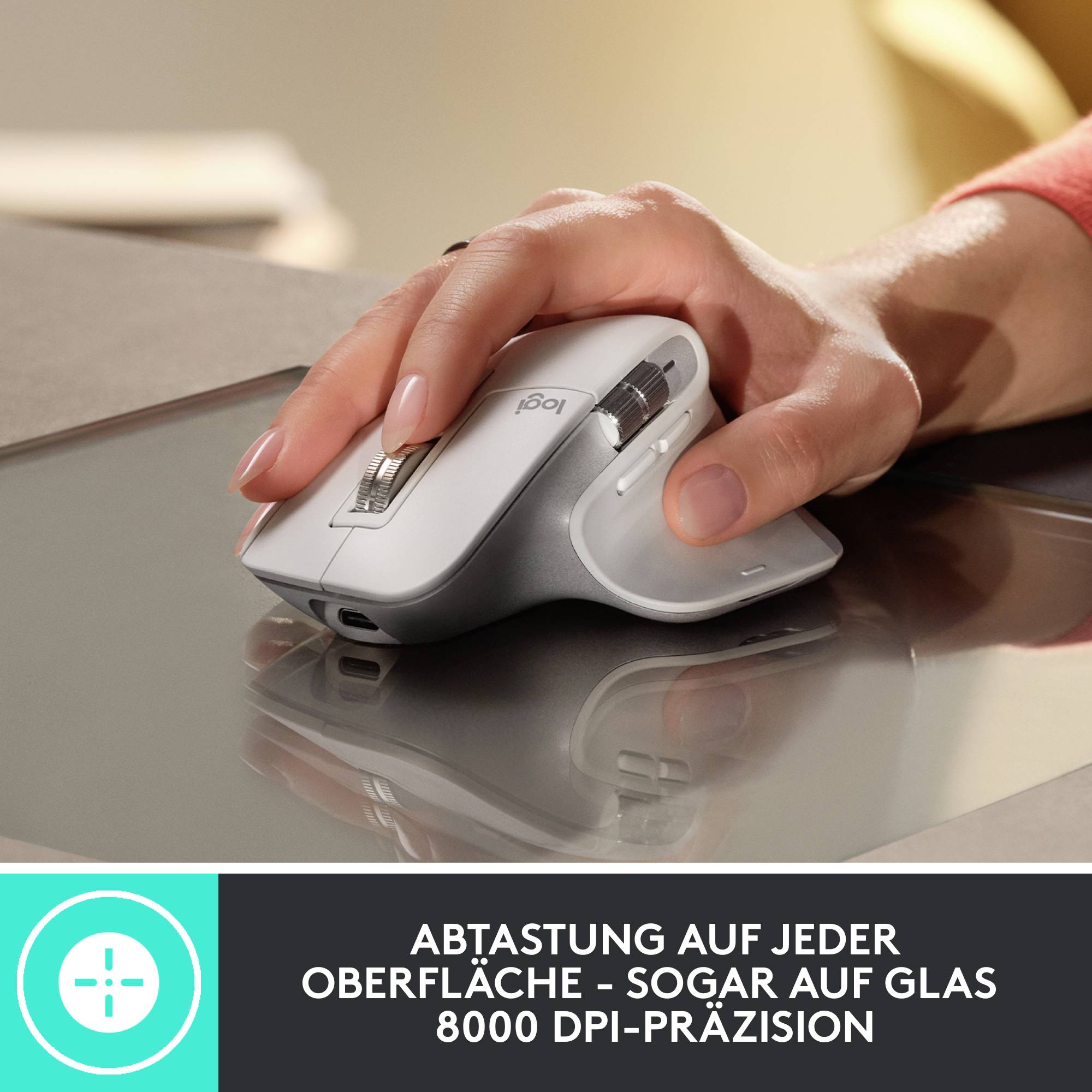 Eine Hand bedient eine ergonomische, silberne Computermaus auf einer Glasoberfläche. Text im Bild: 'Abtastung auf jeder Oberfläche - Sogar auf Glas 8000 DPI-Präzision'.