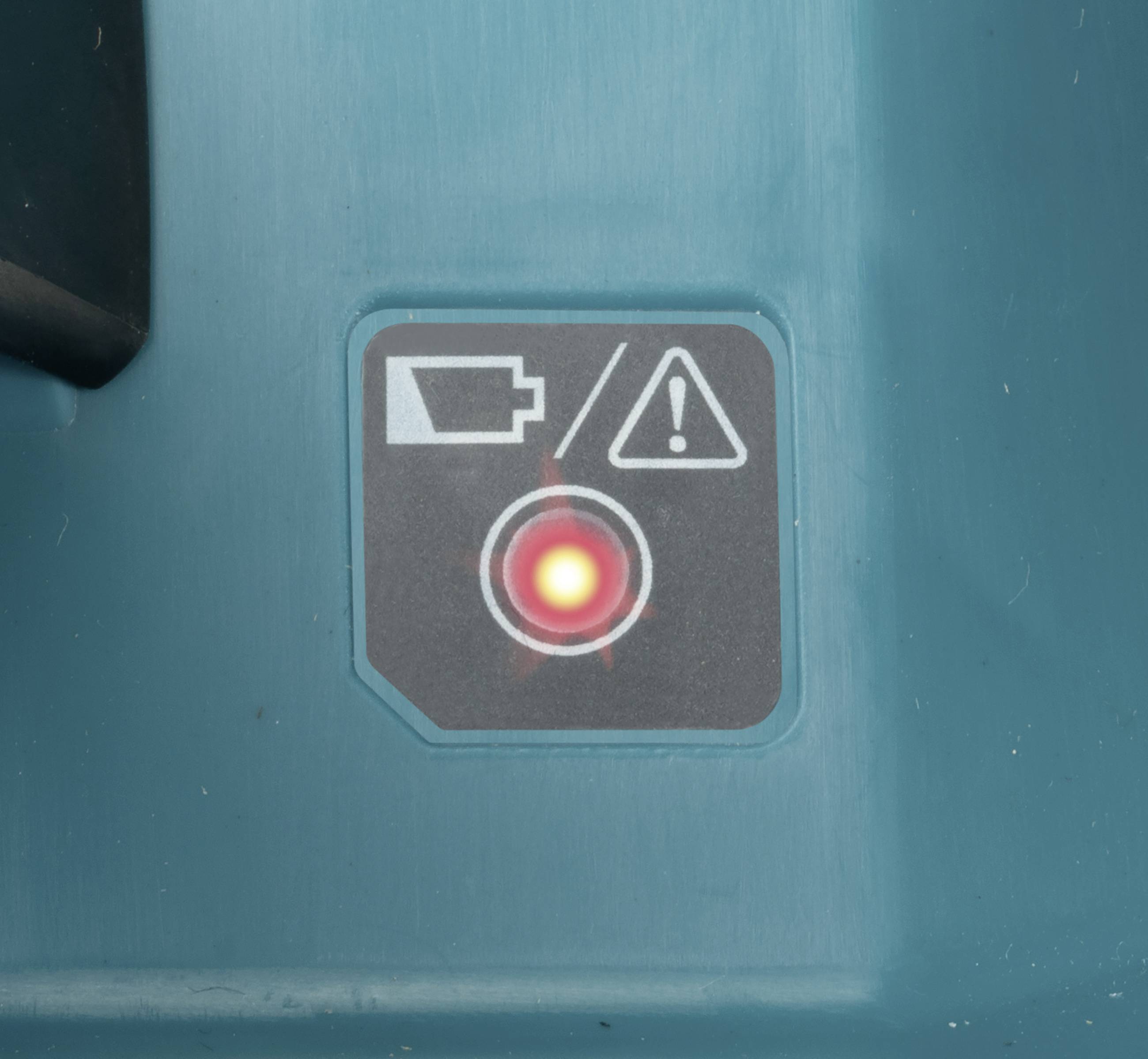 Anzeige auf blauem Hintergrund mit Batteriewarnsymbol, Ausrufezeichen und leuchtendem roten Punkt. Deutet auf niedrigen Batteriestand hin.