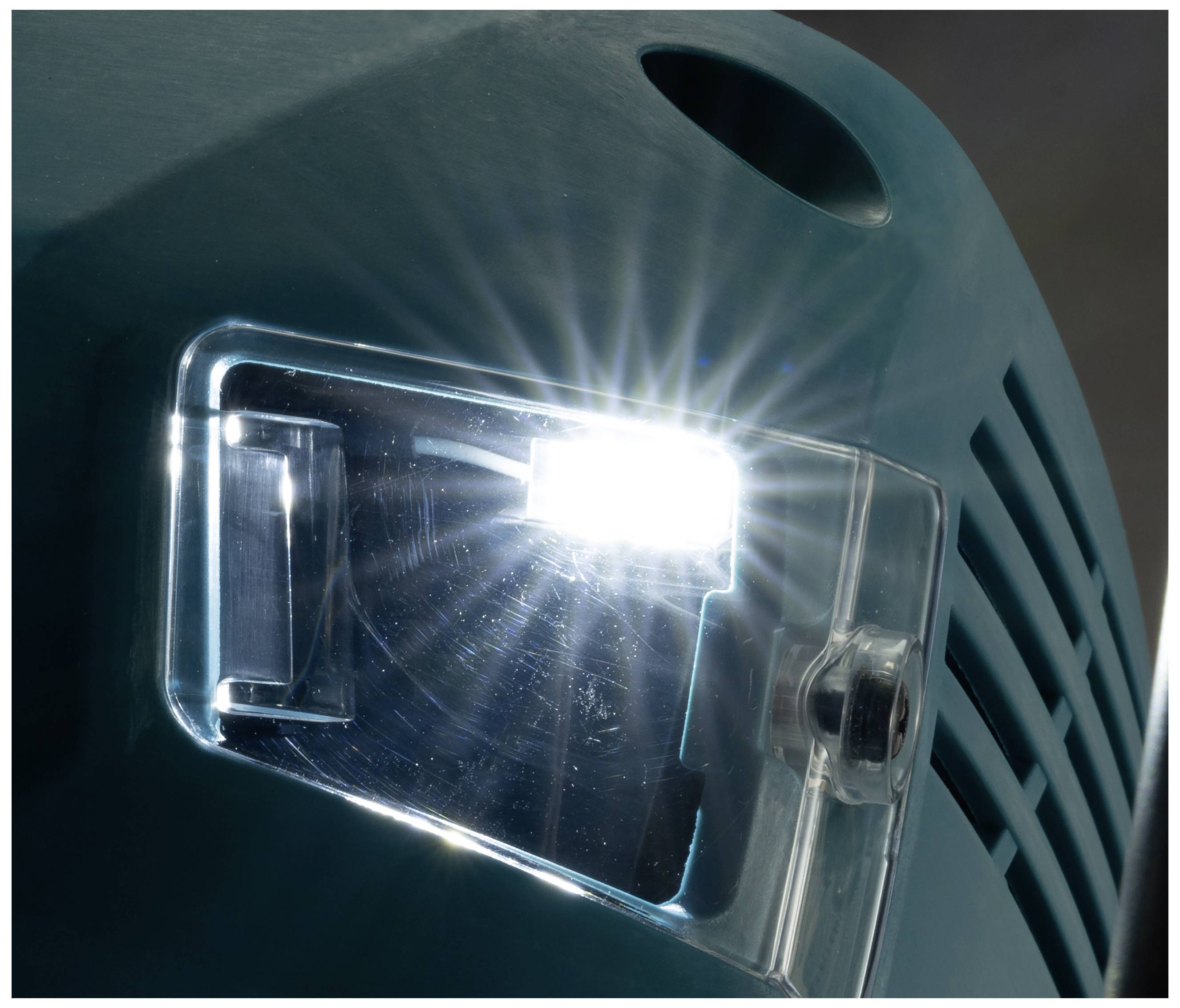 Ein heller LED-Scheinwerfer an einem industriellen Gerät leuchtet. Kunststoffabdeckung und Gehäuseteil sichtbar.