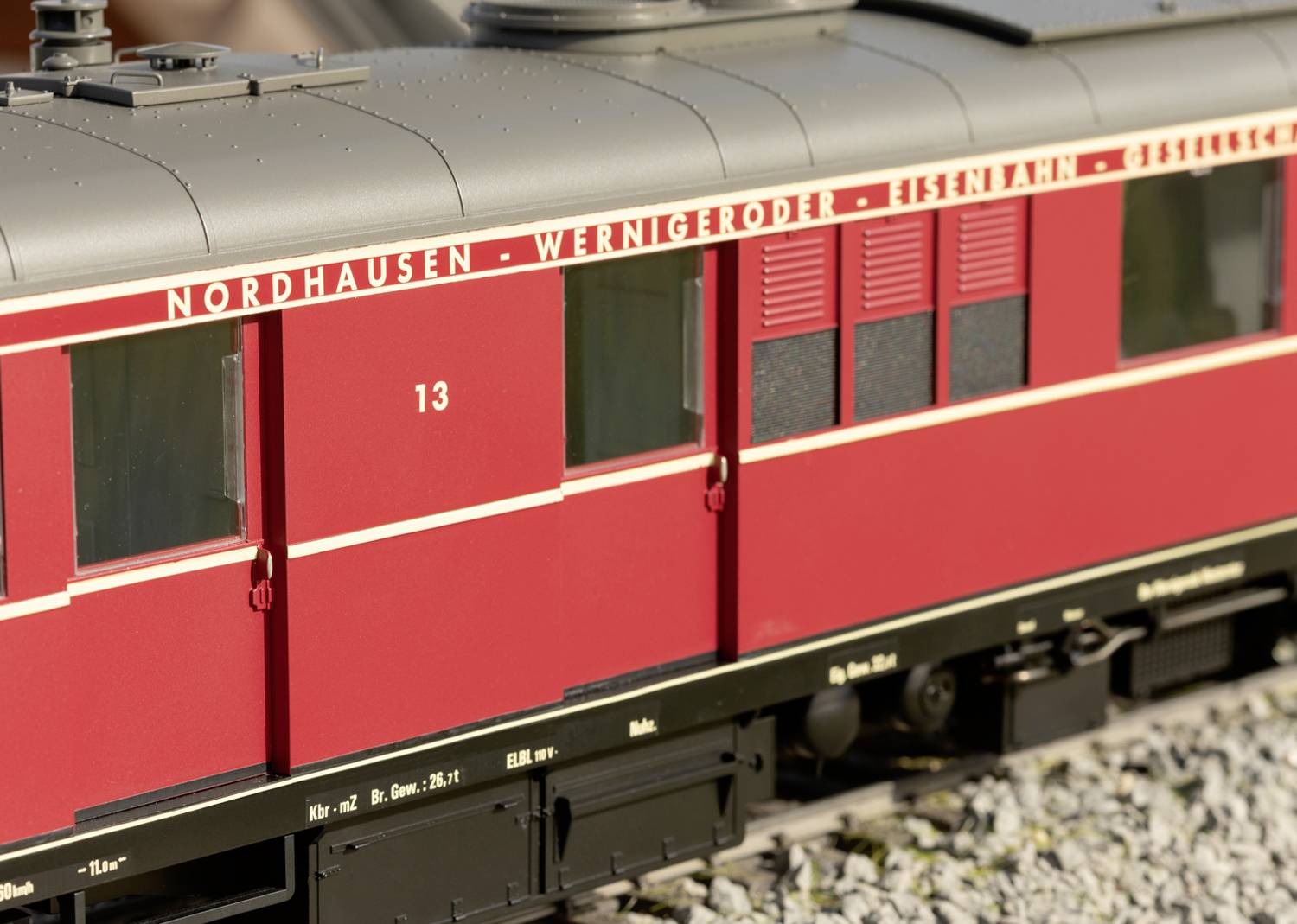 Nahaufnahme eines roten Zugwaggons mit der Aufschrift 'Nordhausen-Wernigerode'. Der Waggon ist auf Schienen abgebildet.
