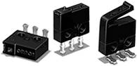 Drei schwarze elektrische Mikroschalter mit verschiedenen Betätigungselementen, nebeneinander aufgestellt.