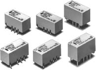 Sechs rechteckige elektronische Bauteile, vermutlich Relais, mit Steckkontakten, in zwei Reihen angeordnet.