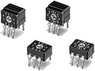 Vier schwarze integrierte Schaltkreise mit mehreren Metallstiften zur elektrischen Verbindung auf weißem Hintergrund.