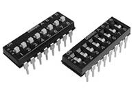 Zwei schwarze DIP-Schalter mit nummerierten Positionen und weißen Schaltflächen, die elektrische Verbindungen steuern.