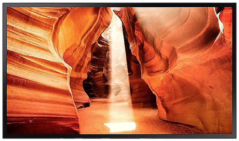 Ein heller Lichtstrahl fällt durch schmale, geschwungene Felsen in leuchtenden Orange- und Rottönen im Antelope Canyon.