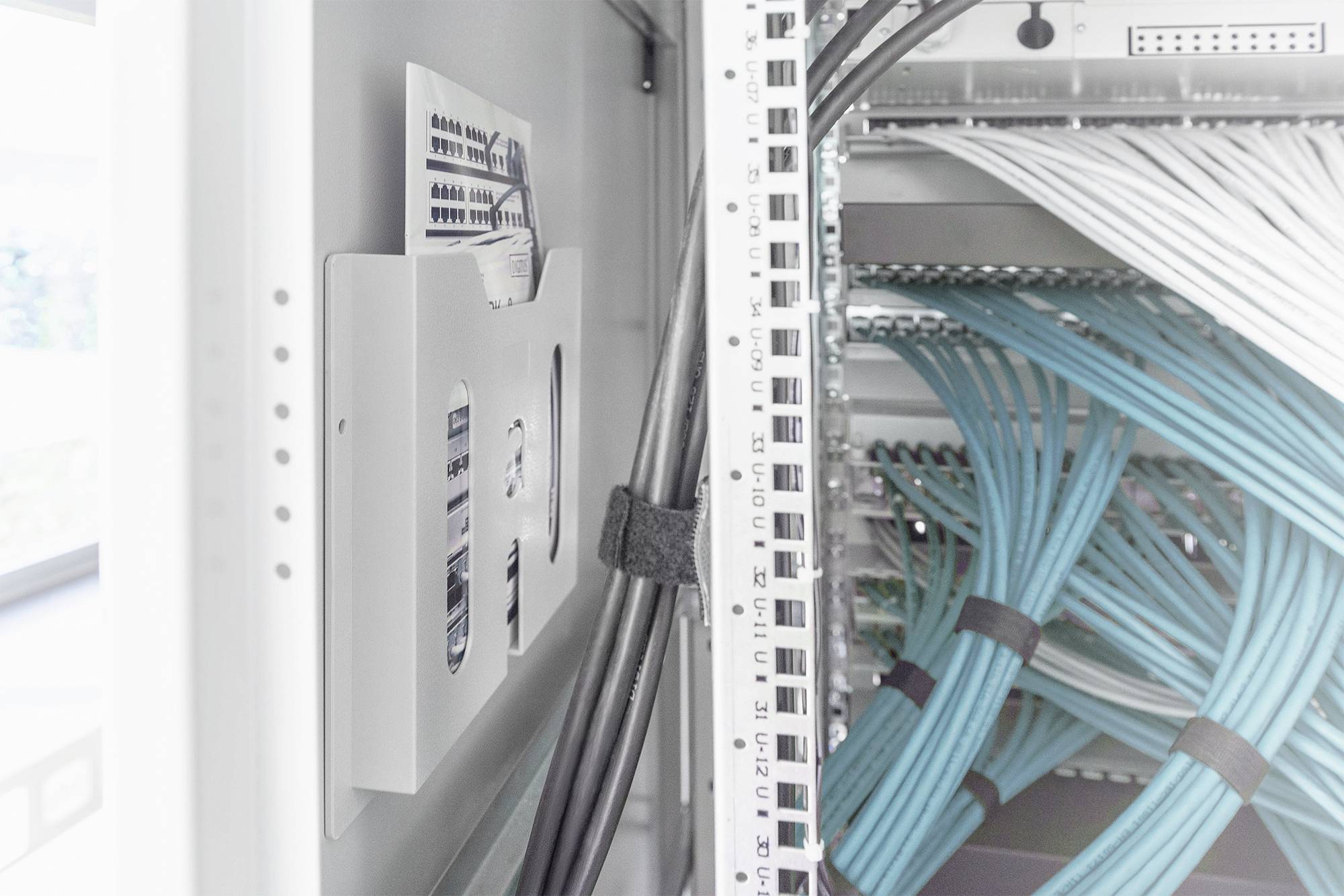 Ein Server-Rack mit blauen Netzwerk- und schwarzen Stromkabeln. Die Verkabelung ist sauber organisiert.