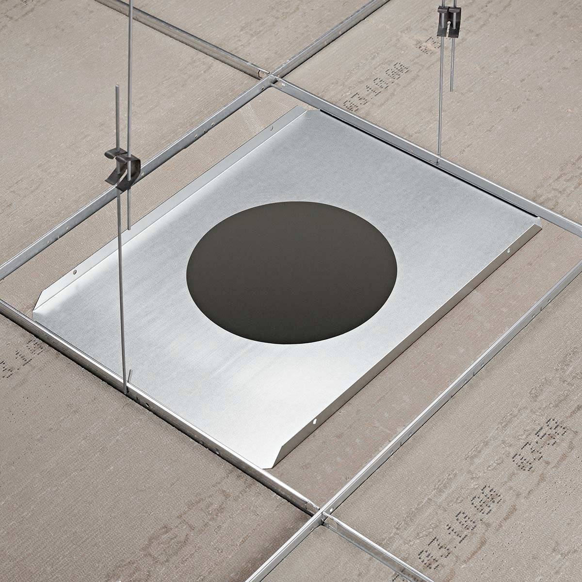 Zementbasierte Platte in Metallschienen aufgehängt, zeigt eine kreisförmige, schwarze Öffnung.