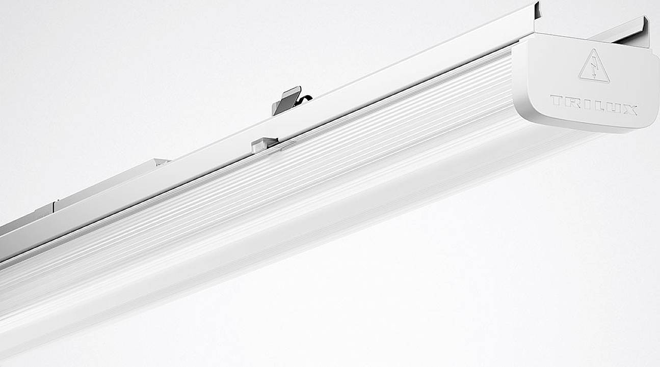 Eine weiße LED-Leuchte mit einem schlanken, rechteckigen Gehäuse und einem kleinen Warnsymbol auf der Seite.
