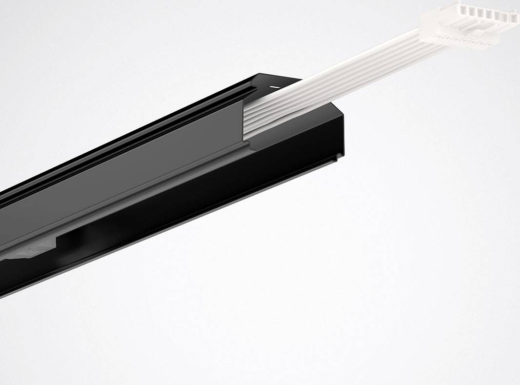 Ein schwarzer Kabelkanal, der weiße Kabel führt, ragt diagonal aus dem Bild heraus.