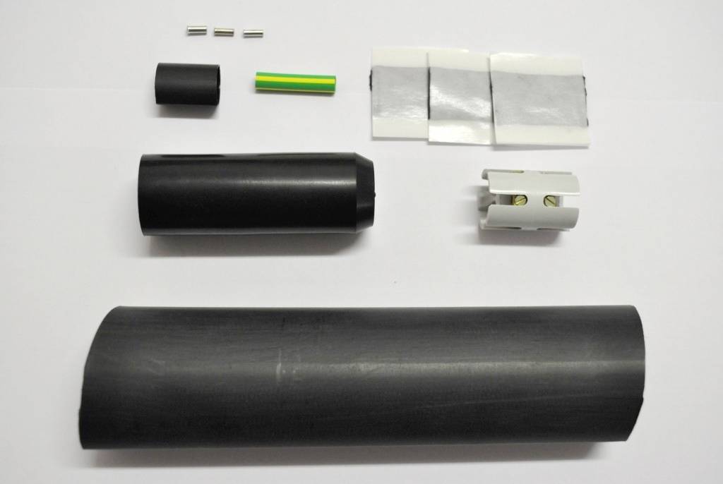 Ein Kabelverbindungssatz mit Schrumpfschläuchen, einem Verbinder, Metallstiften und einer grünen Röhre, die zur Isolation dient.