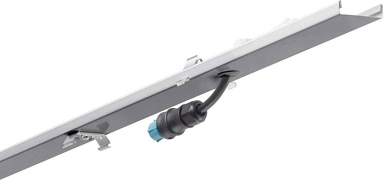 Ein elektrisches Kabel mit Stecker ist an einem großen, flachen Metallteil befestigt. Es könnte Teil eines Aufbaus oder Geräts sein.