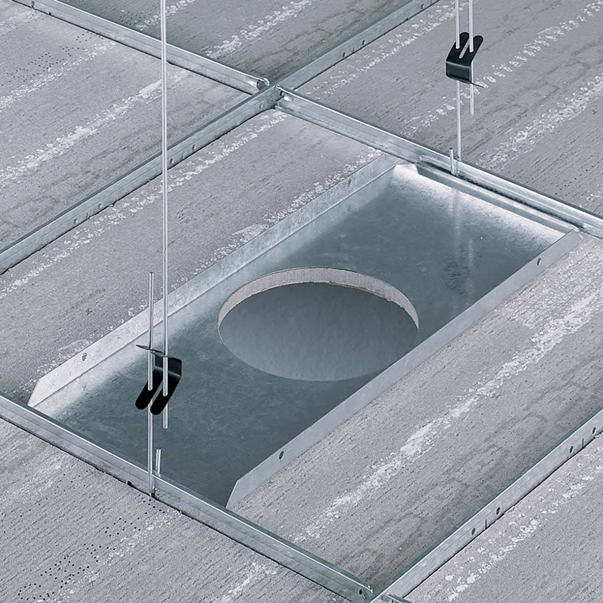Montierte Deckenstruktur mit einer quadratischen Metallöffnung, aufgehängt mit Drahtseilen an einer Betondecke.