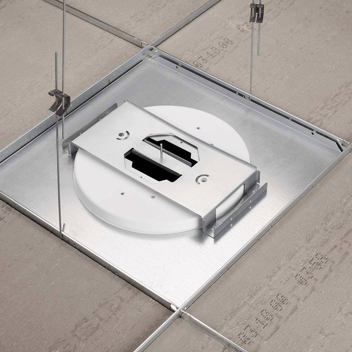 Deckenmontagesystem in einem Gebäude, zeigt eine kreisförmige Halterung innerhalb eines quadratischen Rahmens, befestigt an Stäben.
