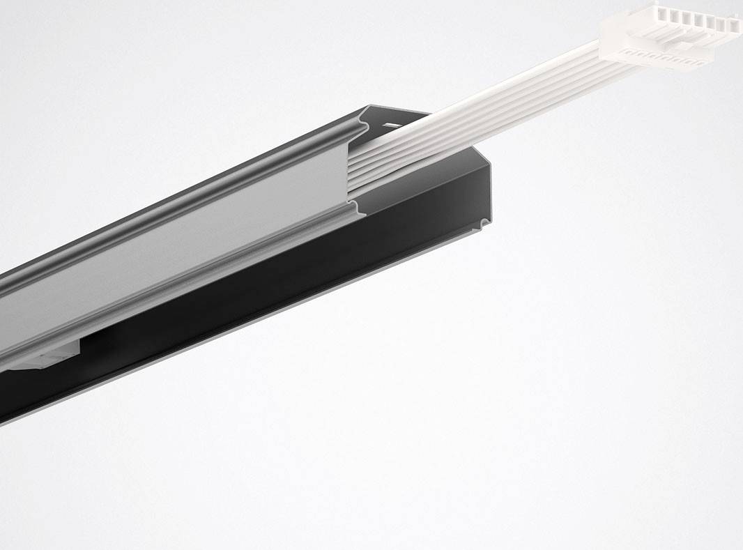 Ein silbernes Schienensystem mit schwarzen Details und Kabeln, das in einer technischen oder industriellen Umgebung verwendet wird.
