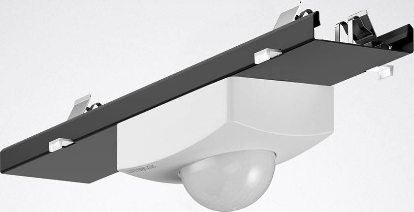 Weiße, runde Deckenleuchte mit schwarzem Befestigungsbalken an der Decke. Moderne, minimalistische Gestaltung.
