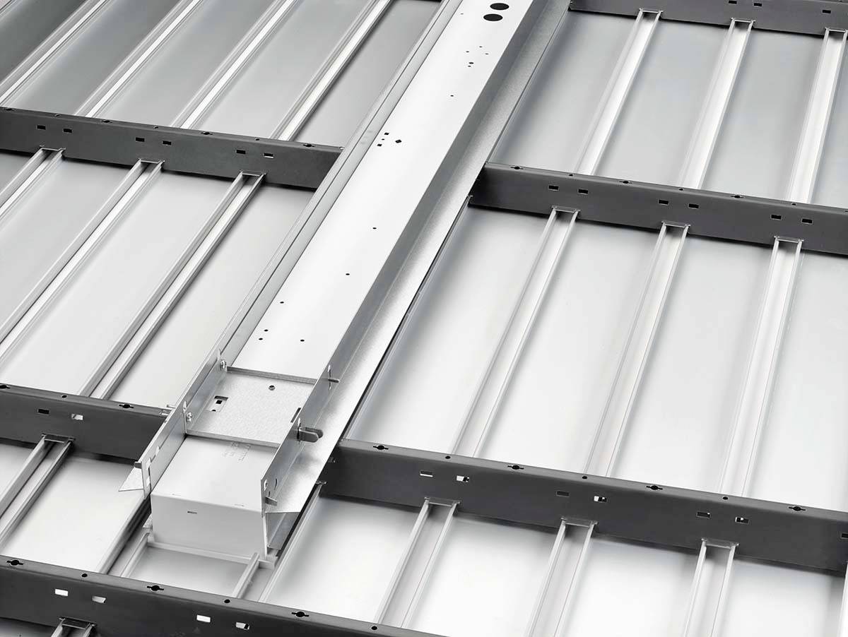 Silberne Metallkonstruktion mit mehreren parallel verlaufenden Streben, die eine stabile Oberfläche bilden, möglicherweise für Bauzwecke.