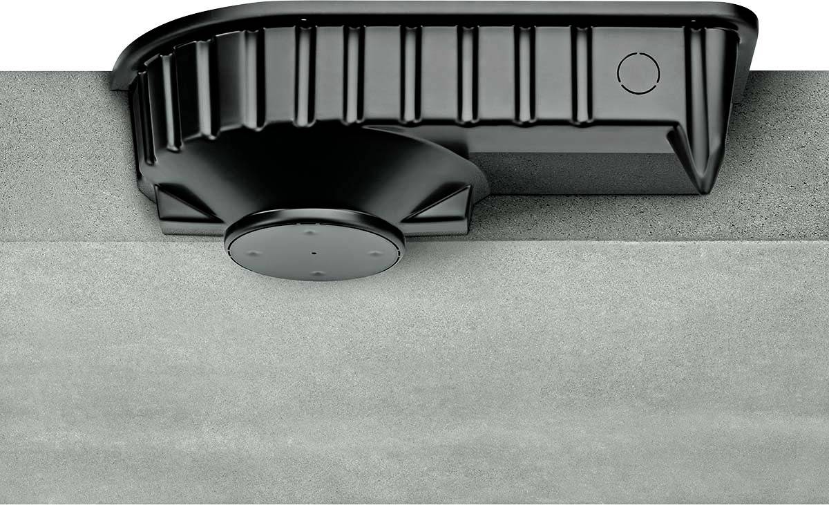 Ein schwarzer Kunststoffkasten ist an der Unterseite einer Betonplatte angebracht.