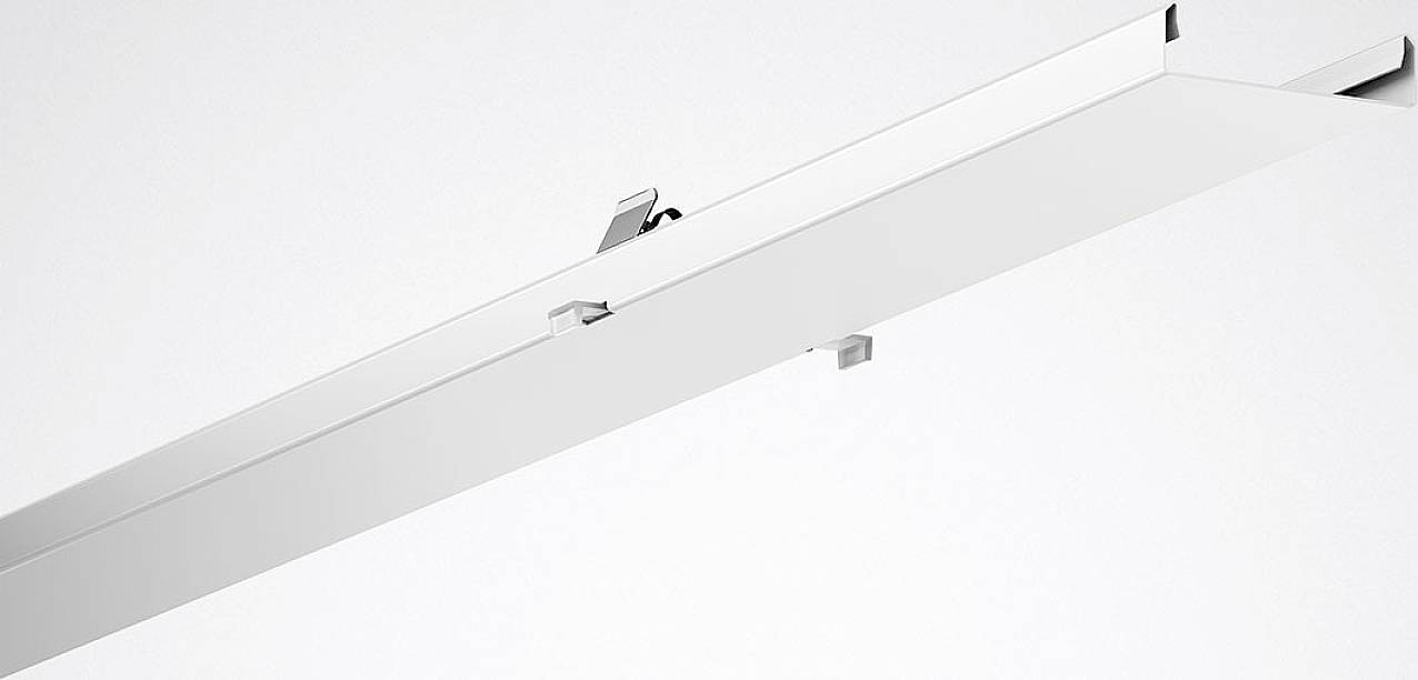 Eine weiße Aluminiumschiene mit mehreren Schlitzen und Clips, die zur Deckenmontage von Leuchten verwendet wird.