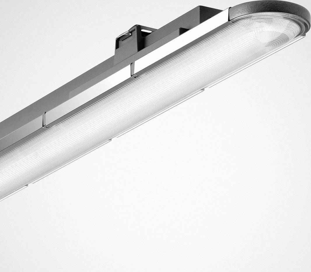 Eine moderne, längliche LED-Deckenleuchte mit silbernem Gehäuse strahlt helles Licht aus und ergänzt ein minimalistisches Interior.
