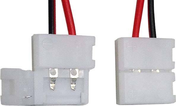 Zwei weiße elektrische Stecker mit roten und schwarzen Drähten, die nebeneinander liegen und bereit zum Verbinden sind.