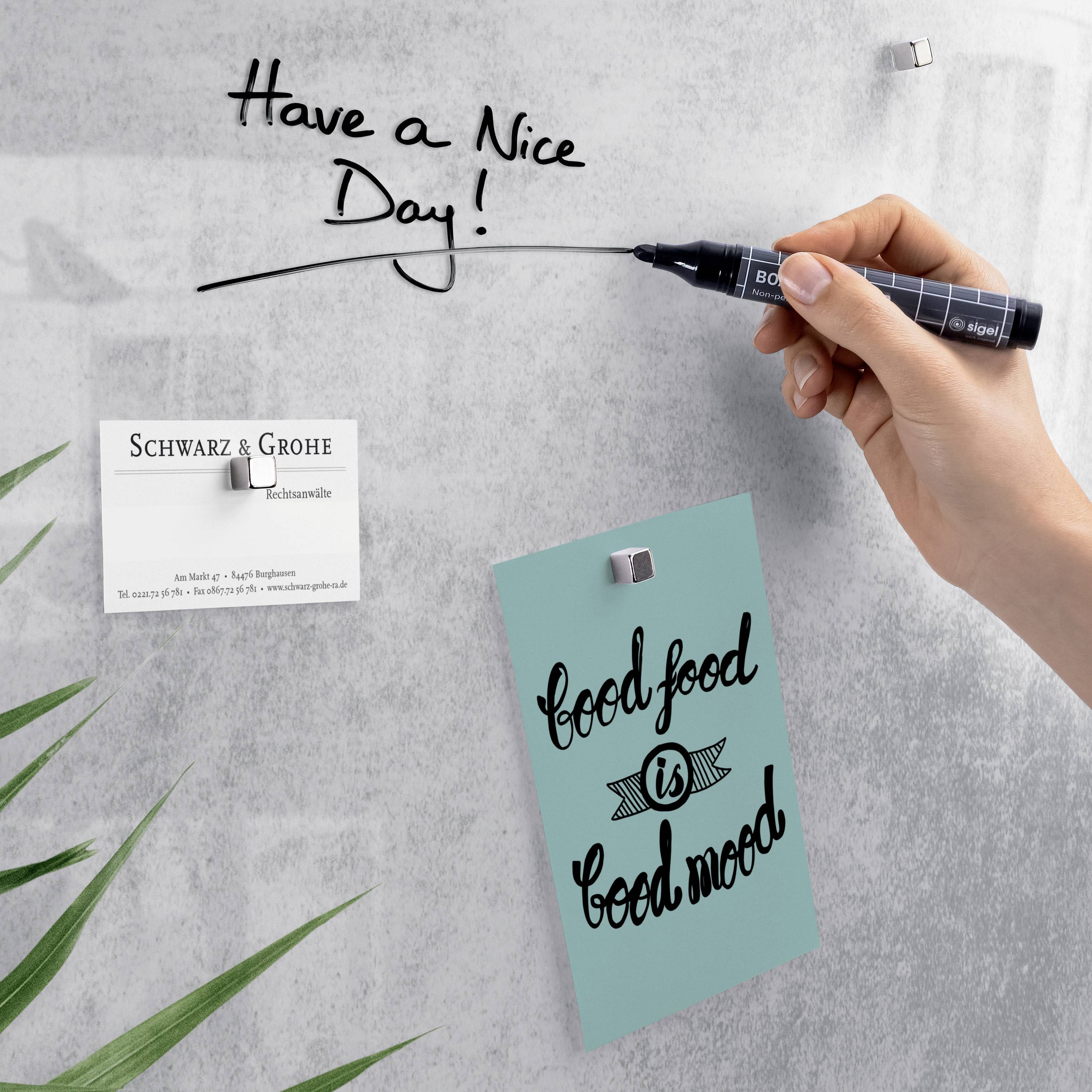 Eine Hand schreibt 'Have a Nice Day!' auf ein Whiteboard. Notiz mit 'good food is good mood', daneben Visitenkarte von 'Schwarz & Grohe'.
