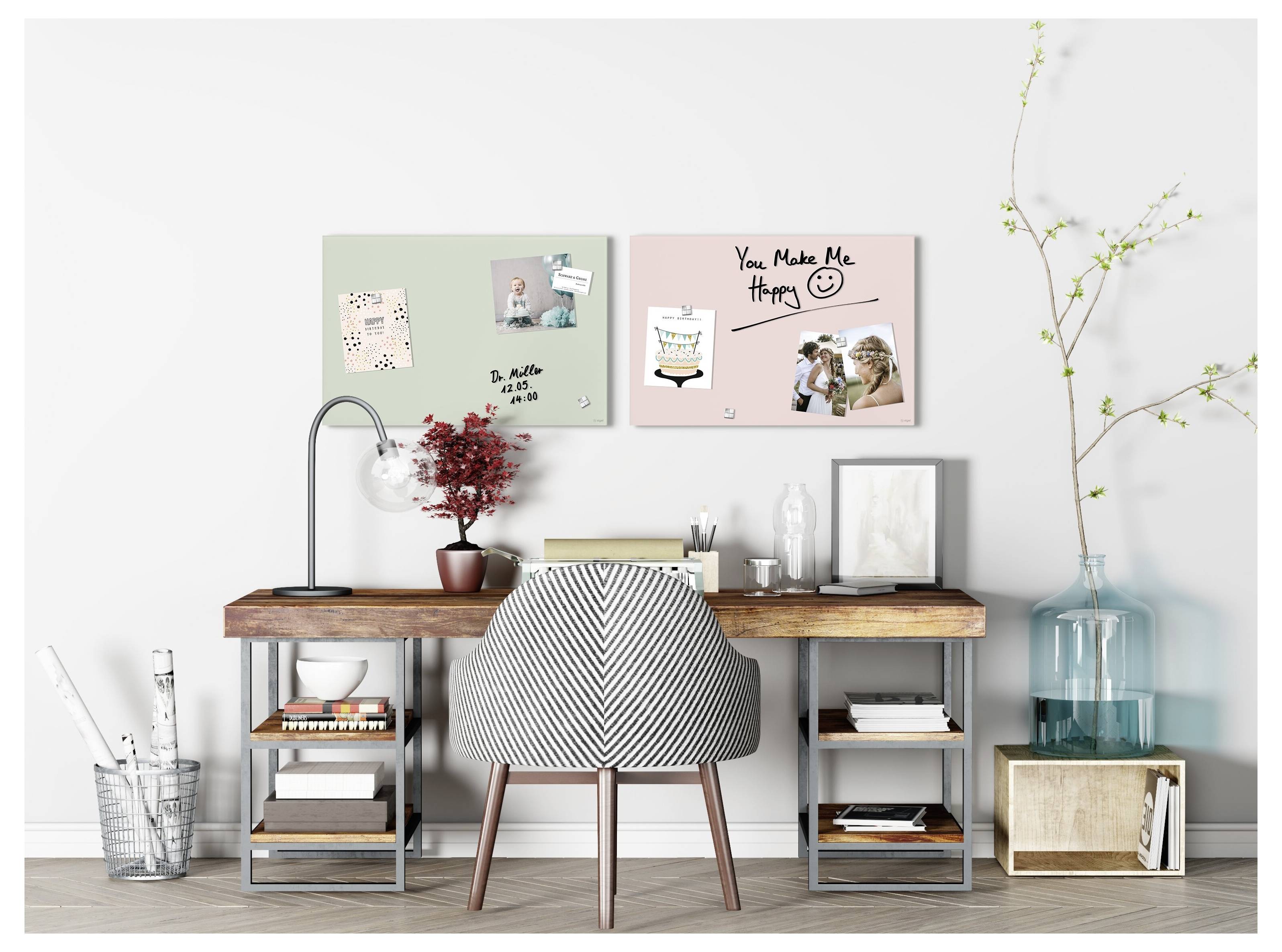 Stilvoller Bürotisch für zuhause mit gestreiftem Stuhl, Regalen, Lampe, Kunsttafeln, Büchern und Dekoration vor einer weißen Wand.