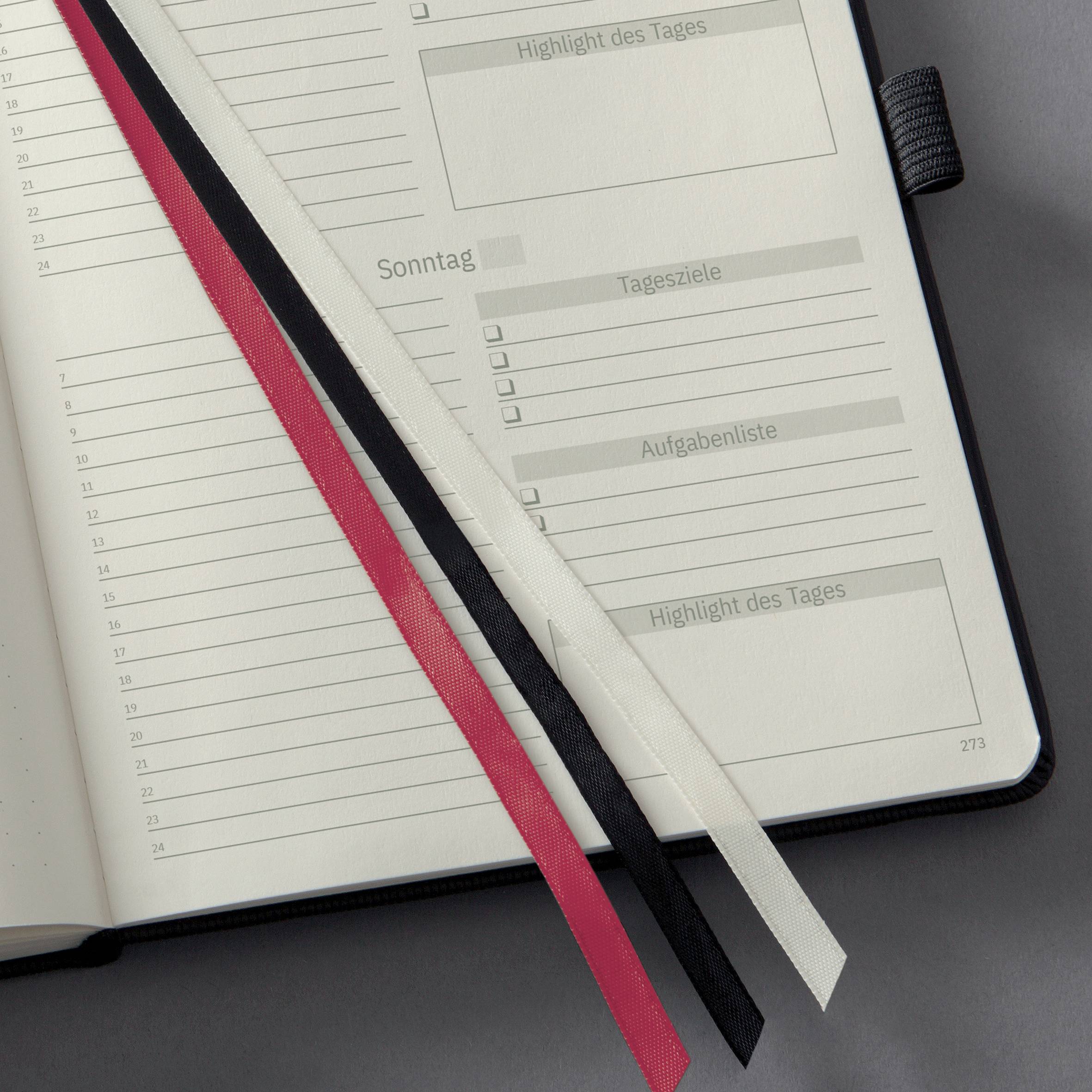 Planer mit geöffneten Seiten. Linien für Notizen, Kategorien wie 'Highlight des Tages', 'Tagesziele'. Lesezeichen in Rot, Schwarz, Weiß.