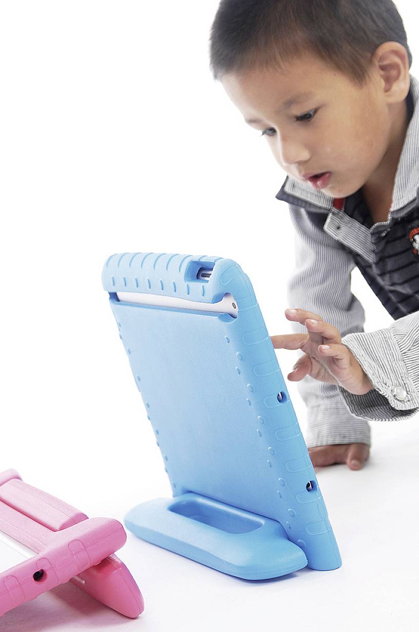 Ein Kind spielt konzentriert mit einem blauen elektronischen Tablet, während es auf dem Boden kniet.