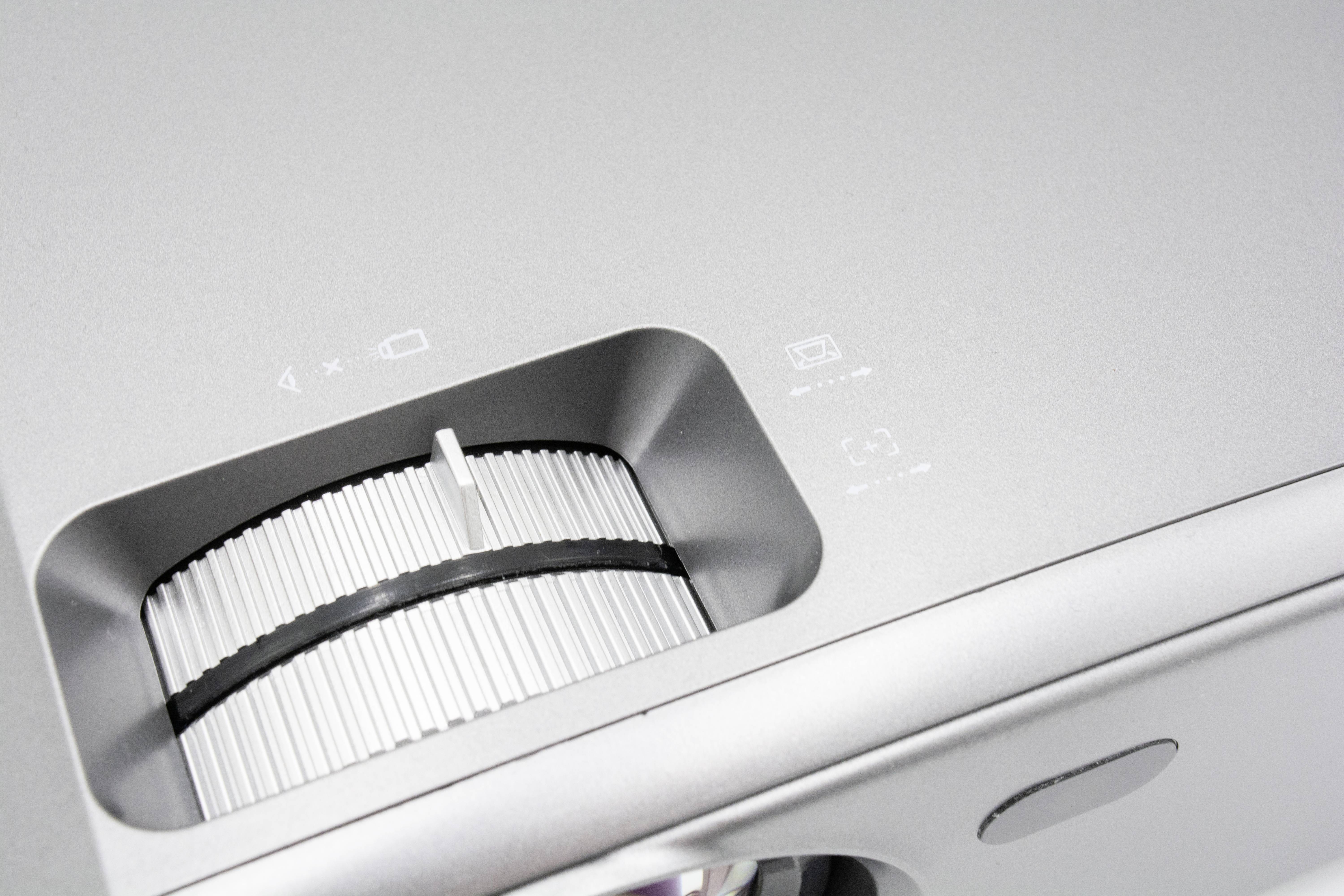 Ein silberner Projektor mit Fokusring und Bedienfeld.