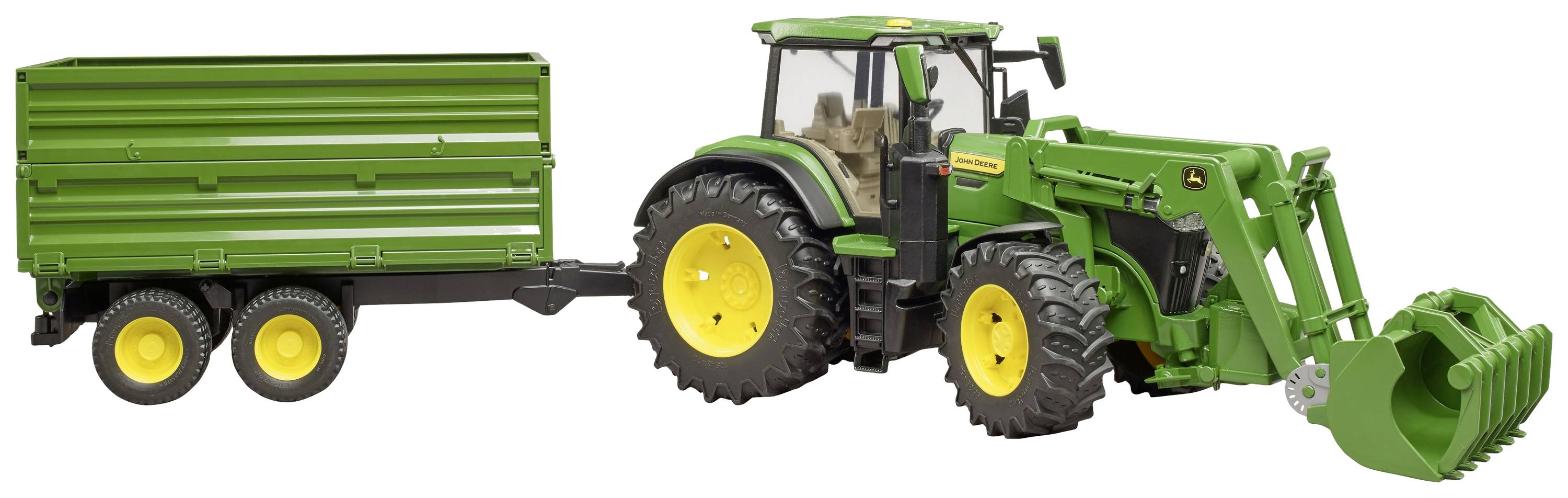 Ein grüner Traktor mit Frontlader zieht einen zweiachsigen Anhänger, beide mit gelben Rädern, auf einer ebenen Fläche.