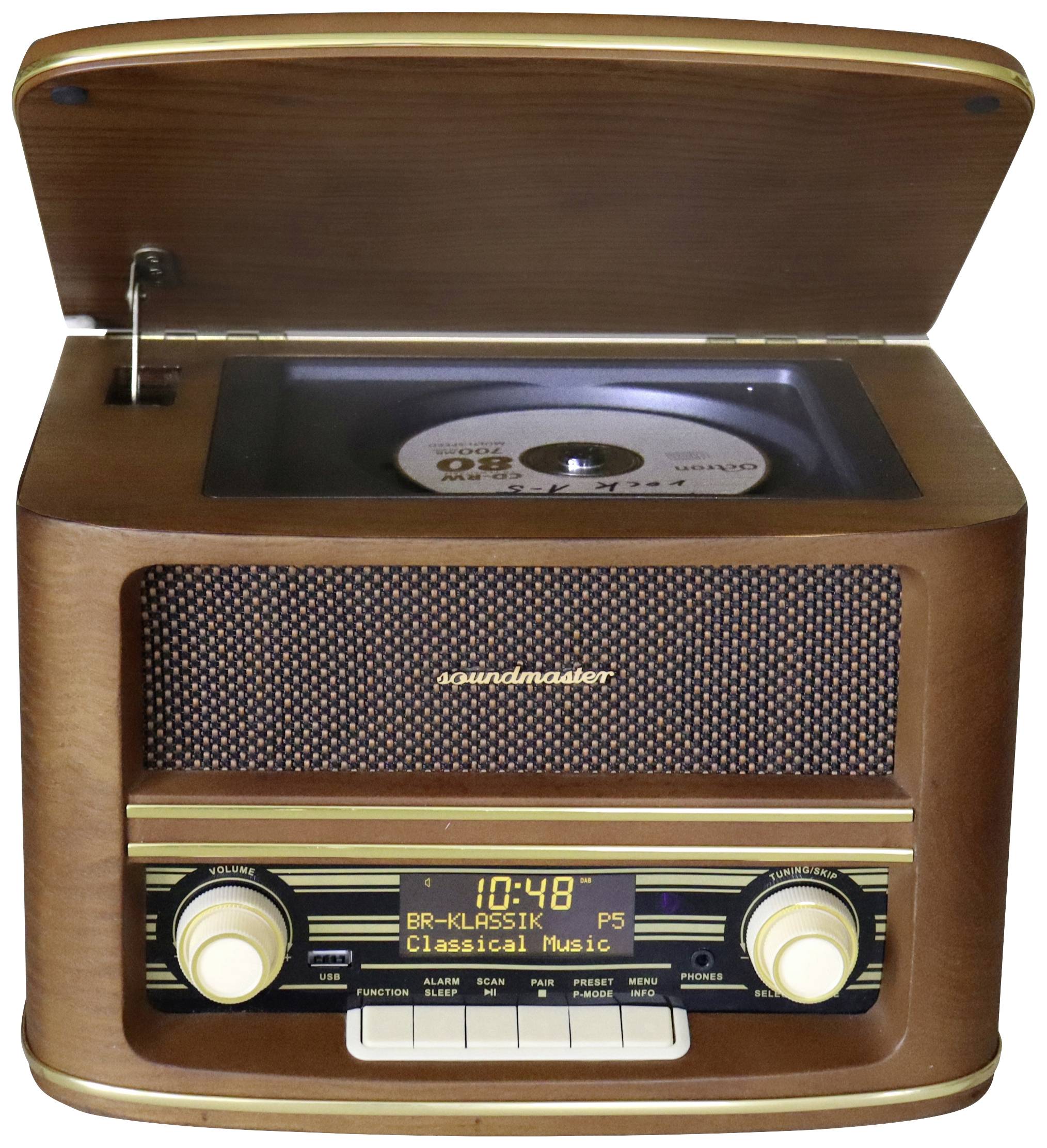Ein Retro-Radiogerät mit offenem Fach zeigt eine CD. Display zeigt 'BR-KLASSIK' und 'Classical Music'. Holzoptik mit goldenen Knöpfen.